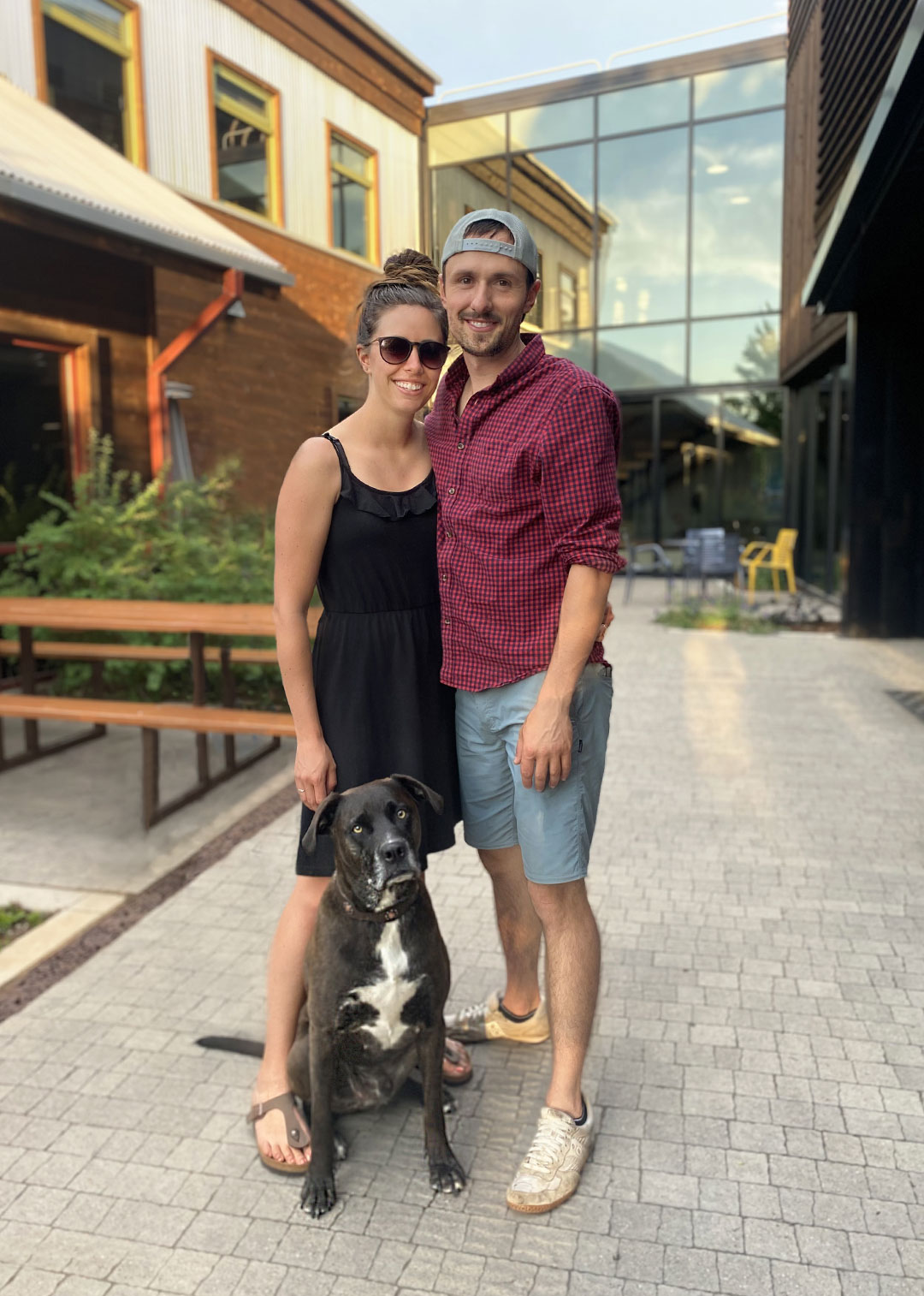 Helios owner and her late husband and dog standing together for a photo taken in front of New Belgium Brewery in fort Collins Colorado.